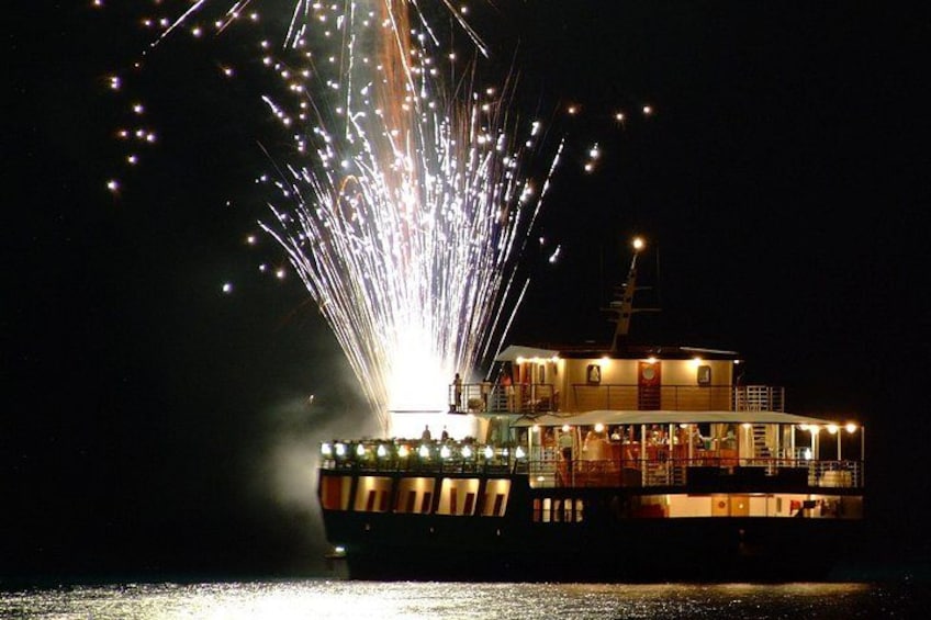 A boat with fireworks exploding above it. 3