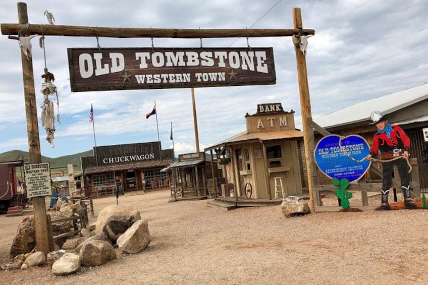 Een stad in western-thema met een bord waarop staat 'Old Tombstone Western Town', een Chuckwagon gebouw, een pinautomaat en een bank. 2