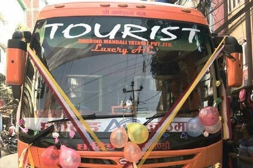 A bus with 'TOURIST' written on the front, decorated with balloons and ribbons. 4