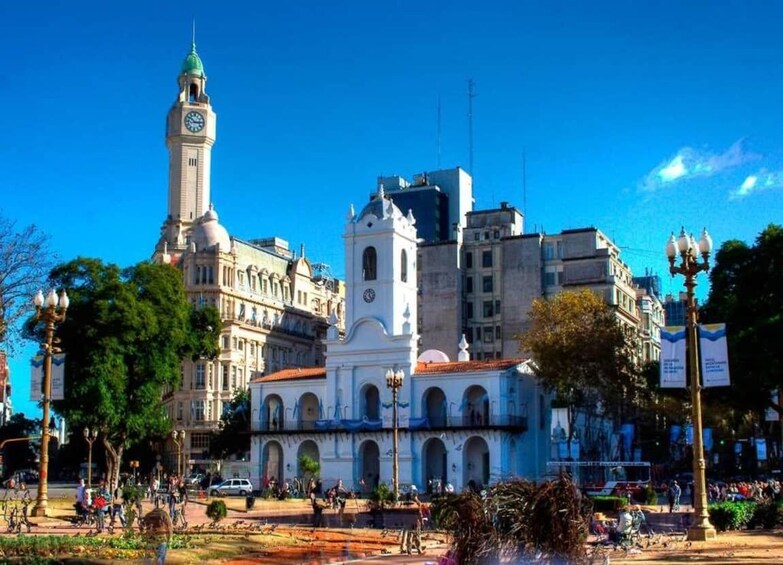 A historic building with a clock tower and a white facade. 3