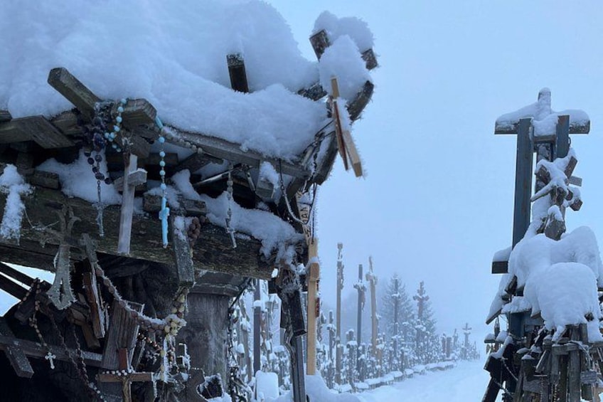 Een met sneeuw bedekte houten constructie met kruizen en een pad op de achtergrond. 4