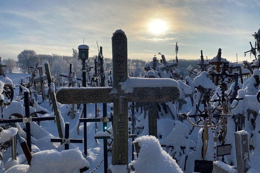 Een met sneeuw bedekte begraafplaats met kruisbeelden en grafstenen. 2