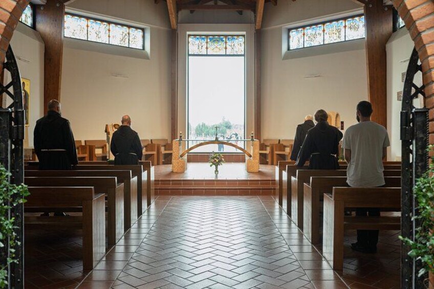 A church interior with pews, stained glass windows, and a central aisle leading to an altar. 5