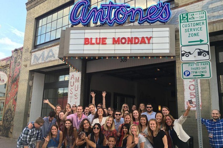 A group of people in front of a theater with a sign reading 'Antone's Blue Monday'. 2