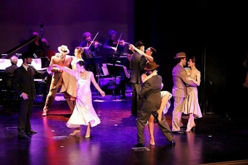 Une scène où des danseurs, vêtus de costumes d’époque, évoluent au rythme d’un orchestre et d’un piano. 2