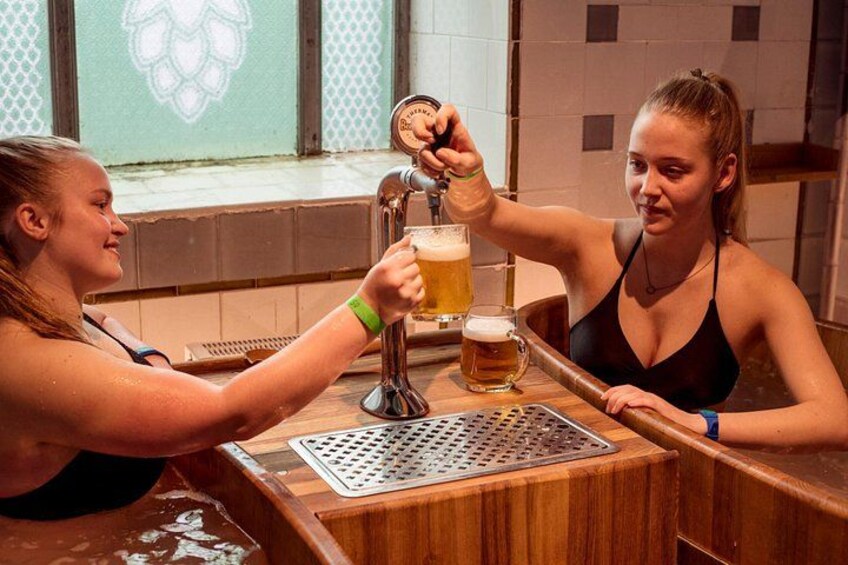 Two people toasting with beer glasses at a bar. 4