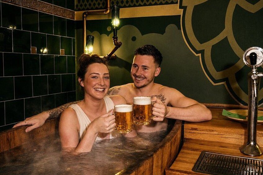 Two people in a hot tub holding beer mugs. 2