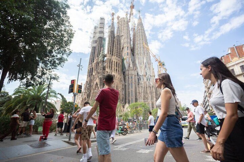 Una calle concurrida, gente caminando y un gran edificio histórico al fondo. 2