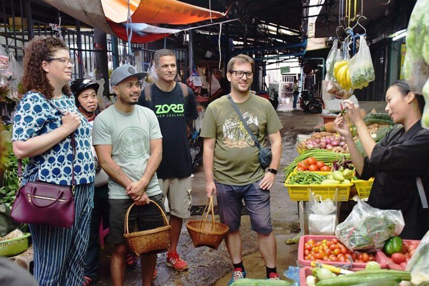 A market scene with people shopping and vendors selling produce. 3