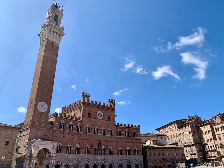 A historic building with a tall clock tower and arched windows. 1