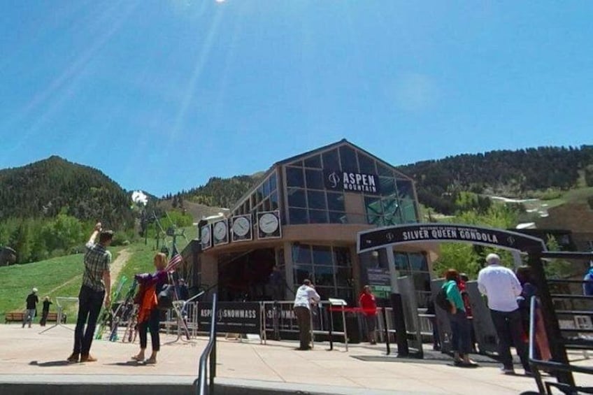 A mountain lodge with a sign reading 'Aspen Mountain' and 'Silver Queen Gondola' in a mountainous area. 5