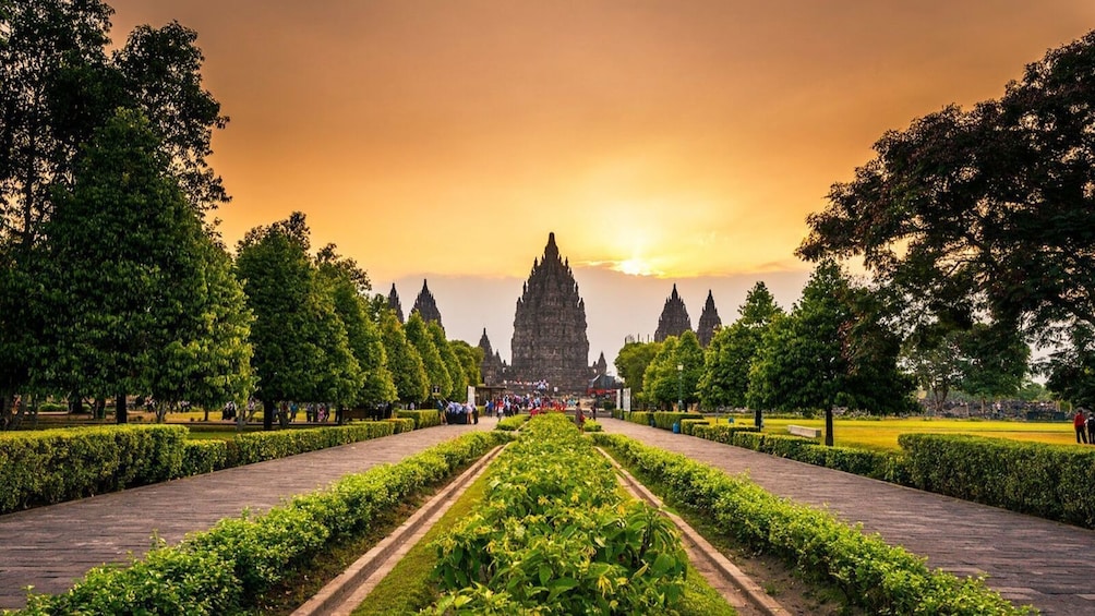 Candi Prambanan saat senja - menara candi merah muda dalam cahaya matahari terbenam sebelum pertunjukan Ramayana Ballet dimulai