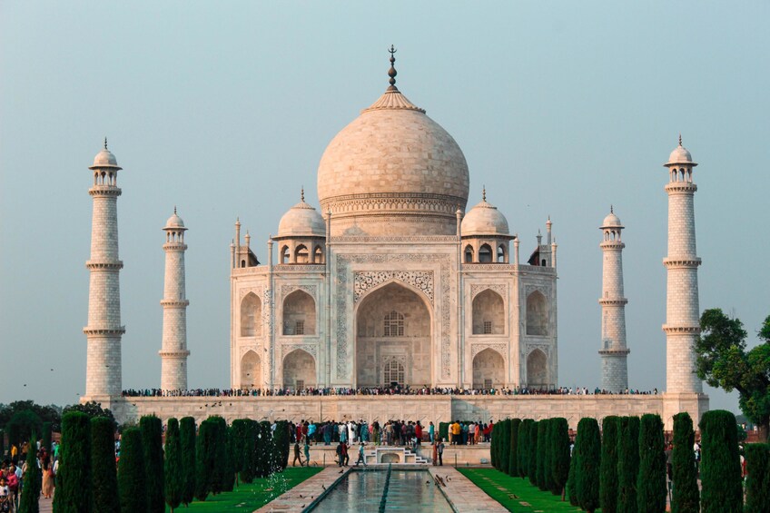 Taj Mahal, jossa on neljä minareettia ja suuri keskusdome, ja sen ympärillä on puutarha ja heijastuslampi. 2