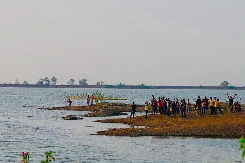 A group of people gathered on a lakeside shore. 4