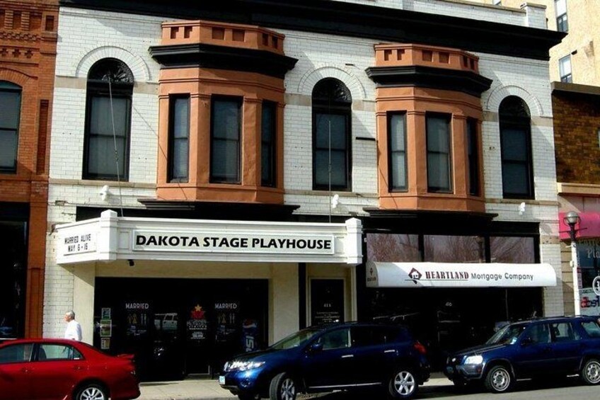 Un edificio con un cartel para Dakota Stage Playhouse y Heartland Mortgage Company. 5