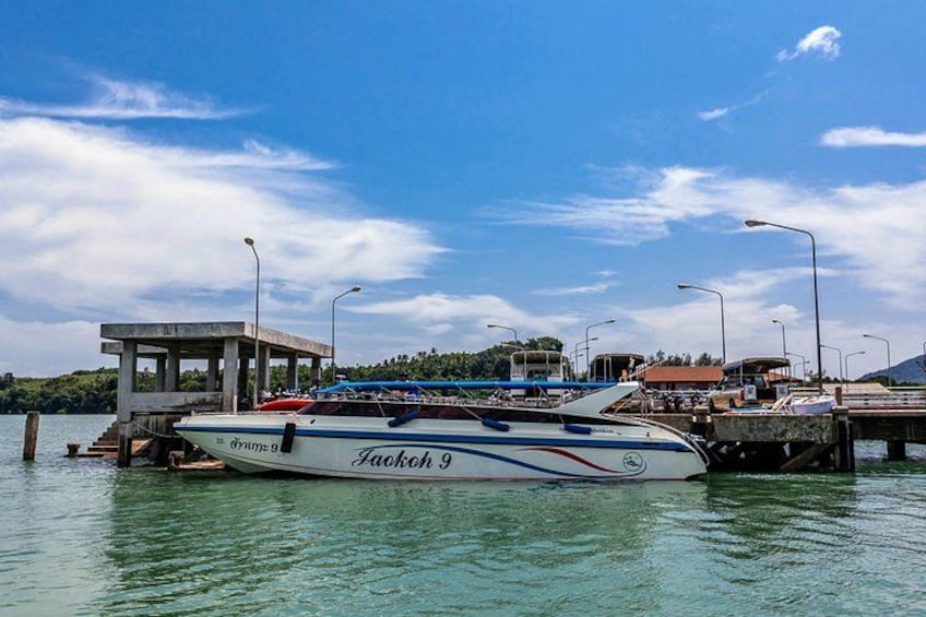 A boat named 'Jackok 9' docked at a pier with a clear sky and a distant shoreline. 5