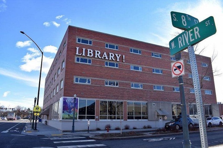 A library building with 'LIBRARY!' signage, located at the intersection of S. 8th St. and W. River St. 5
