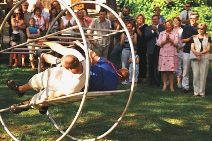 Una persona realiza una acrobacia en un aparato circular mientras un público observa. 2