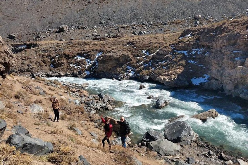 A river flowing through a rocky landscape with people standing on the banks. 2