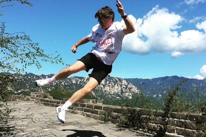 A person running on a stone path with mountains in the background. 1