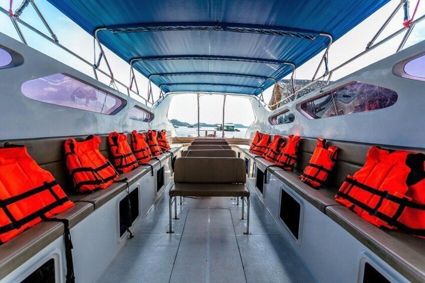 A boat deck with rows of red life jackets and a blue canopy. 5