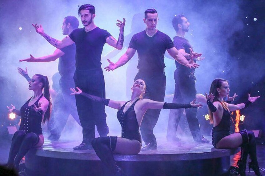 A group of dancers performing on stage with smoke effects. 2