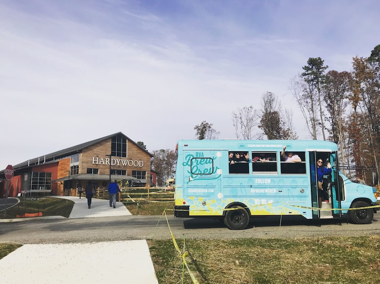 Un camion-restaurant bleu est garé devant un bâtiment portant l’inscription « HARDWOOD ». 1