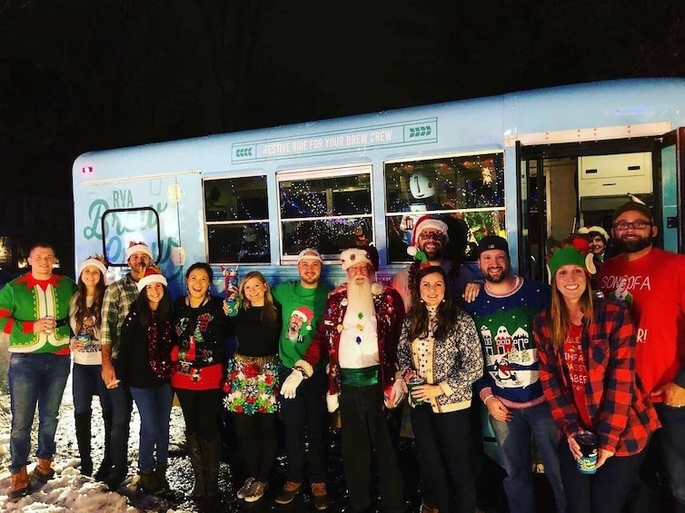 Un groupe de personnes vêtues de tenues festives se tient devant un autobus décoré, sur lequel on peut lire l'inscription : « Une virée festive pour votre équipe de brasseurs. » 2