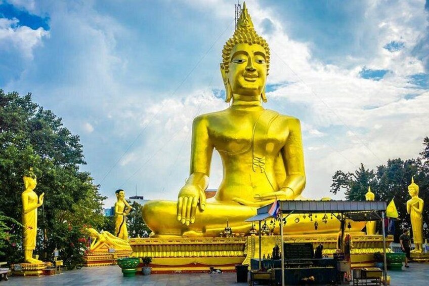 En stor gyllene Buddha-staty omgiven av mindre gyllene statyer och traditionell arkitektur. 4