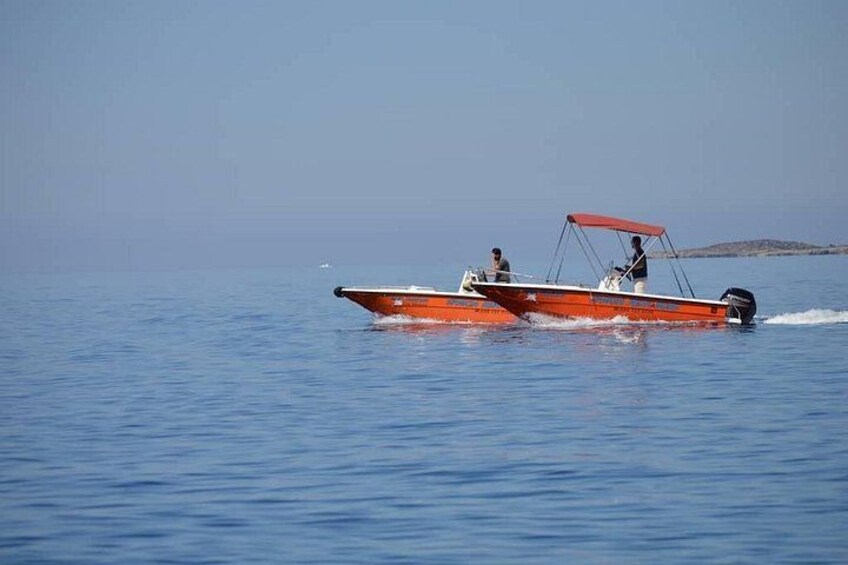 A red speedboat with two people on the water. 5