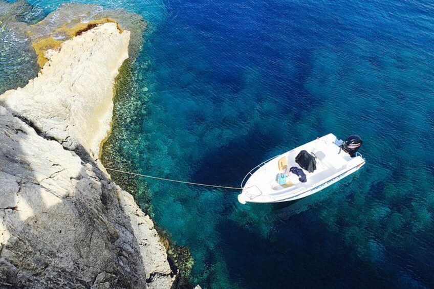 A boat tethered to a rocky coastline. 3
