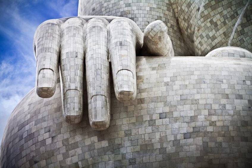 A large, textured sculpture resembling a hand with fingers extended. 3