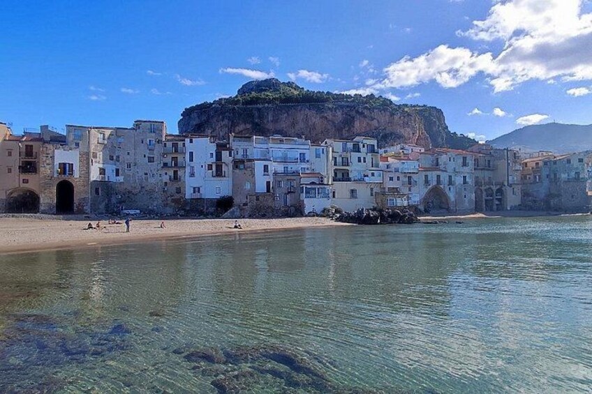 Eine Küstenstadt mit Häusern, einem Strand und einer Klippe. 2