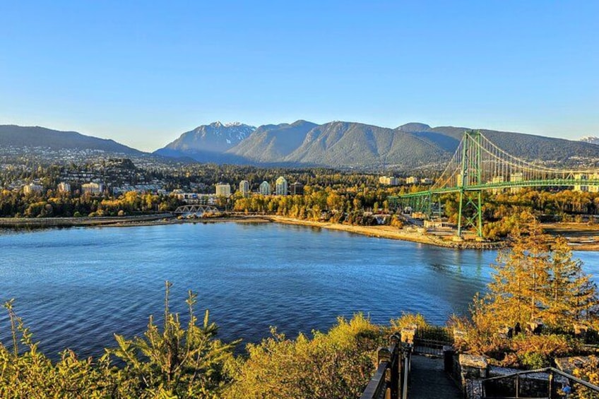 Une rivière traversée par un pont, des montagnes et un paysage automnal. 1