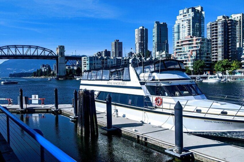 Un grand yacht était amarré dans une marina, avec la silhouette de la ville et un pont en arrière-plan. 3