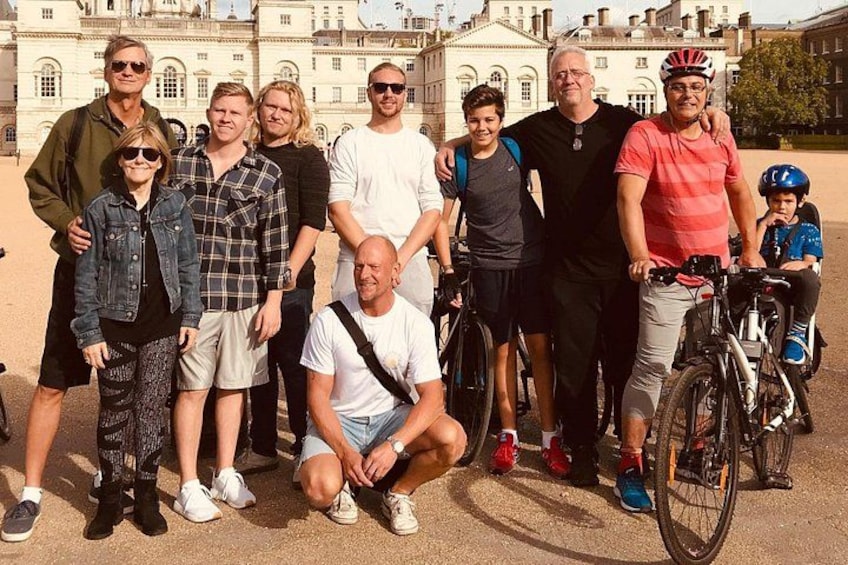 A group of people posing in front of a historic building with classical architecture. 1