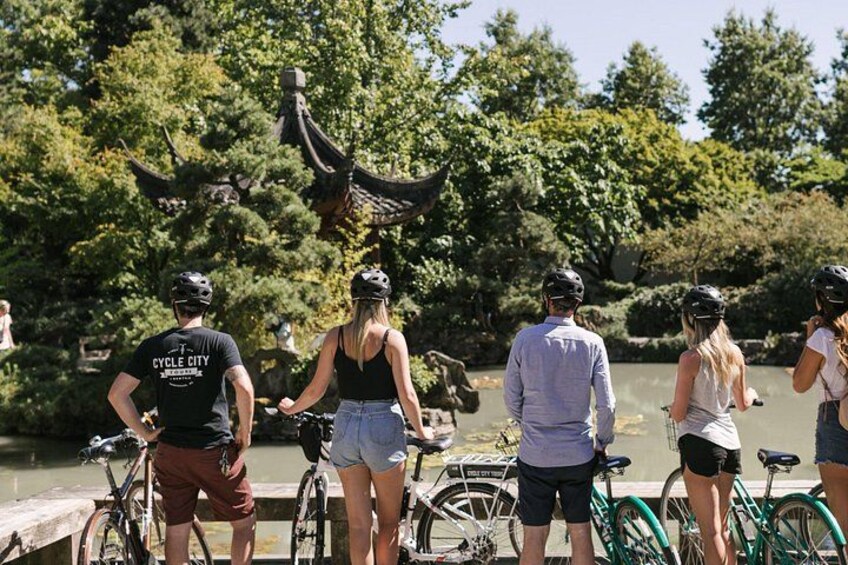 Un grupo de personas en bicicleta cerca de un cuerpo de agua, con árboles al fondo. 2