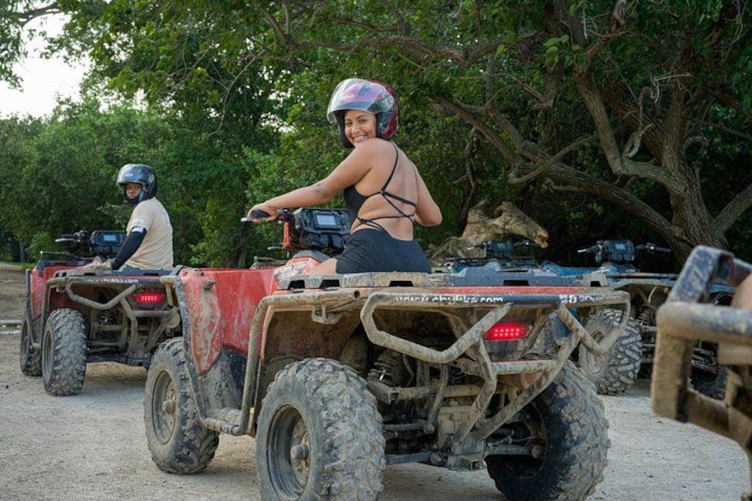 Two off-road vehicles on a dirt path with trees in the background. 2