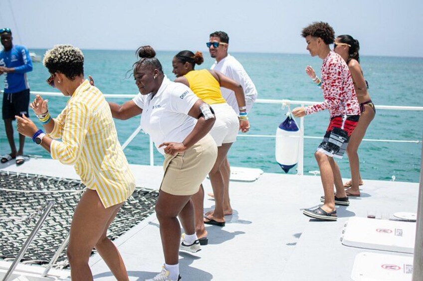 People dancing on a boat with the ocean in the background. 5