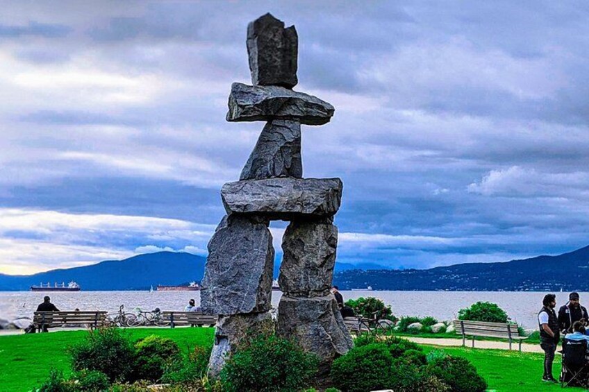 Un totém en un parque con un lago y montañas al fondo. 3
