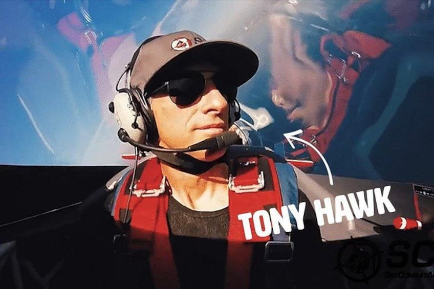 A person wearing a headset and a red vest with 'TONY HAWK' written on it. 3