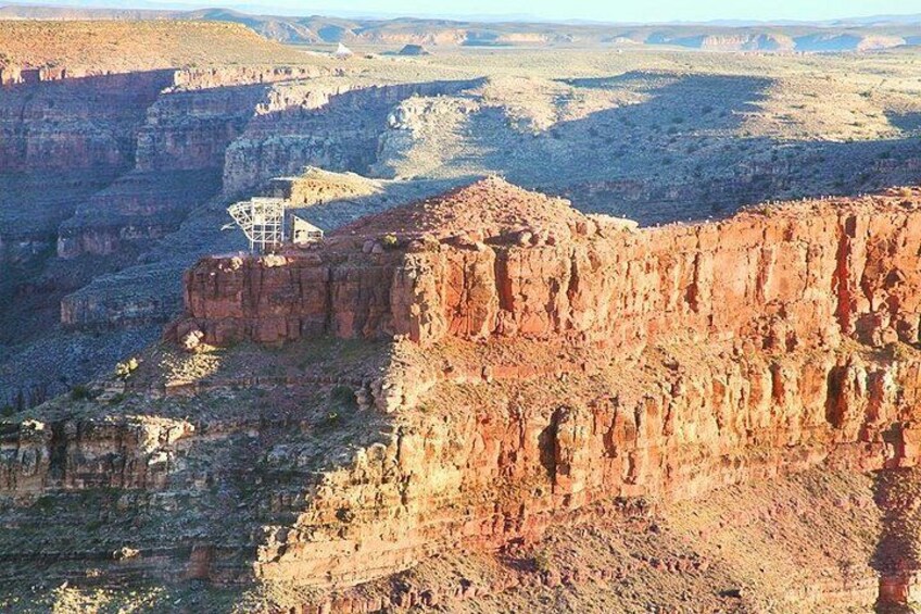 A canyon with a structure on a cliff edge. 5