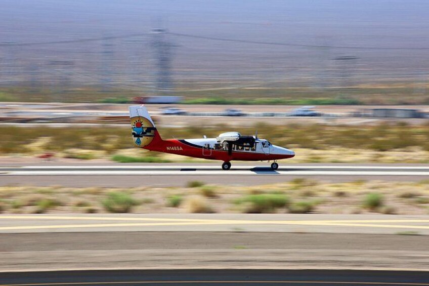 A small aircraft with a red and white livery on a runway. 3