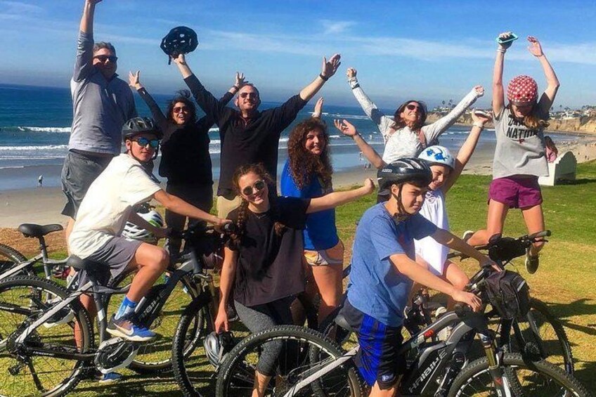 A group of people on bicycles by the beach. 5