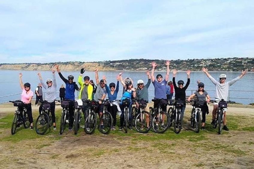 A group of cyclists on a coastal path with the ocean in the background. 4