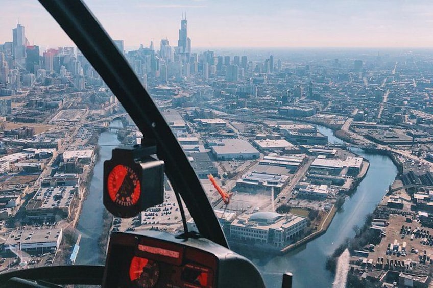 Vista aérea de una ciudad con un río, edificios y un helicóptero. 3