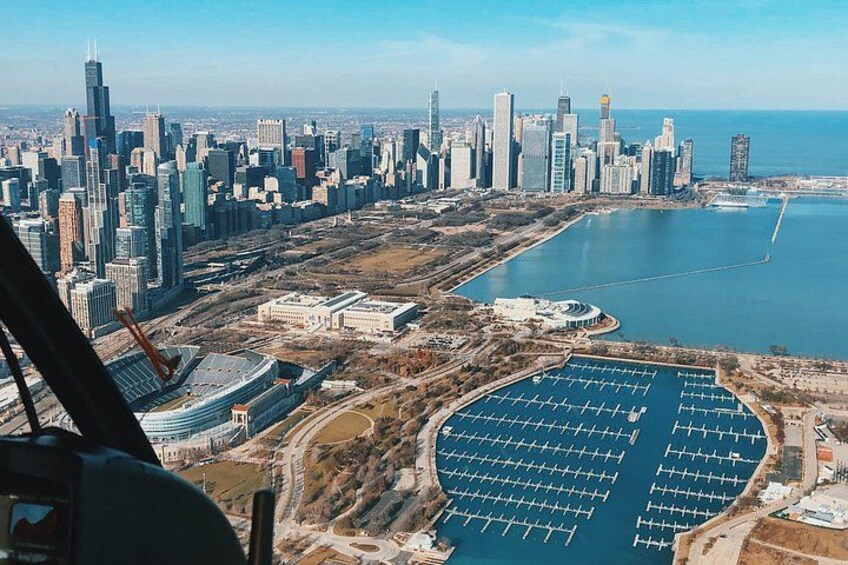 Un horizonte urbano con rascacielos, una gran masa de agua y un helipuerto. 4