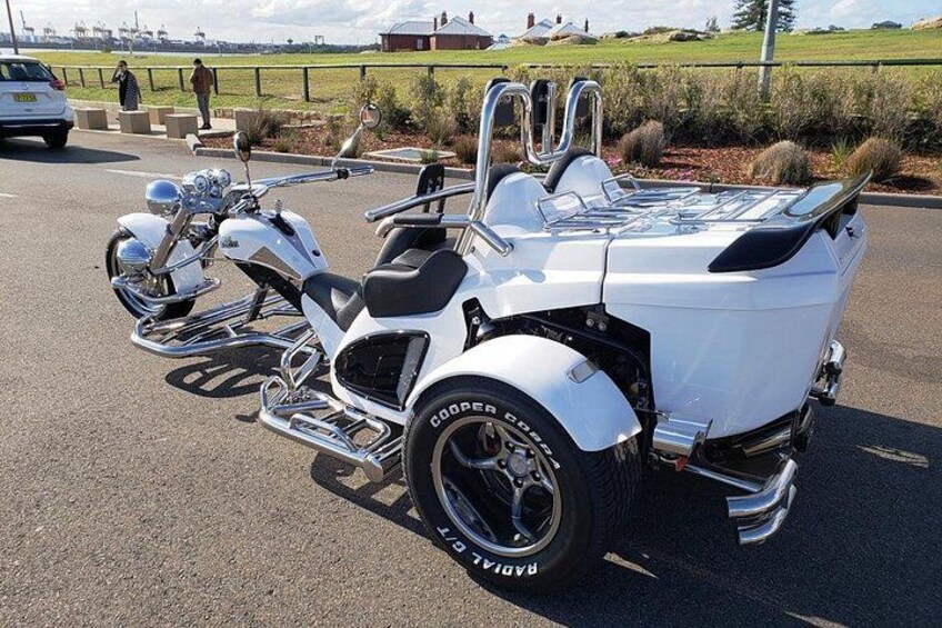 Eine weiße Motorrad mit Beiwagen steht an einer Straße. 3