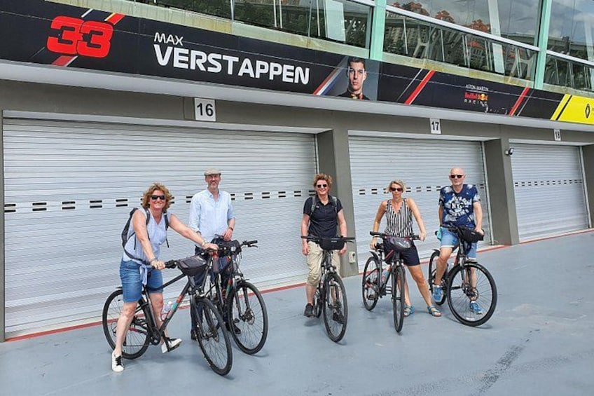 A group of people on bicycles in front of a building with the number 16. 4