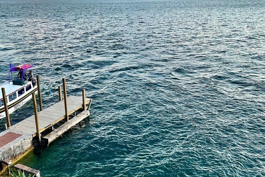 A boat docked at a pier extending into a body of water. 4